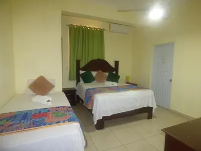 a bedroom with two beds and a green curtain at Hotel Enrique I Gazcue, Bed and Breakfast in Santo Domingo