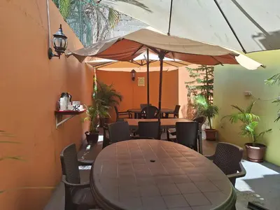 a dining room with a table and chairs and an umbrella at Hotel Enrique I Gazcue, Bed and Breakfast in Santo Domingo