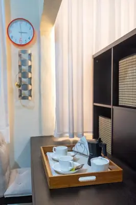 a tray with cups and bowls on a table with a clock at Acogedor estudio 7 en la Zona Colonial in Santo Domingo