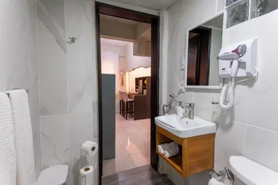 a white bathroom with a sink and a mirror at Acogedor estudio 7 en la Zona Colonial in Santo Domingo