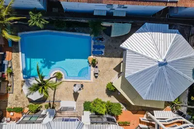 an overhead view of a swimming pool with an umbrella at One Bedroom Apartment in Sosua , Great for Remote Workers Fast Wifi in Sosúa