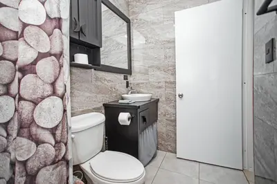 a bathroom with a toilet and a stone wall at One Bedroom Apartment in Sosua , Great for Remote Workers Fast Wifi in Sosúa