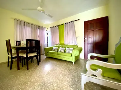 a living room with a green couch and a table at Hotel María Bonita Higüey, Apartments in Higuey