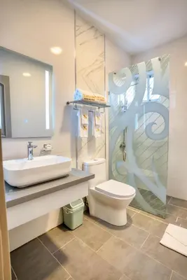 a bathroom with a sink and a toilet and a shower at Naranjo Hotel Boutique in Higuey