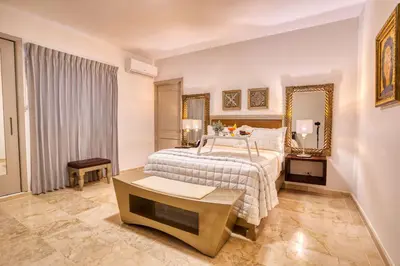 a large bedroom with a bed and a mirror at Naranjo Hotel Boutique in Higuey