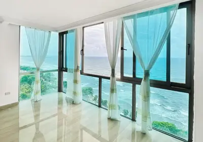 a room with large windows and the ocean at Exclusive 3 BDR, Gym & Pool, SeaView, Luxury Tower in Santo Domingo