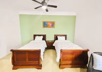 two beds in a room with a ceiling fan at Exclusive 3 BDR, Gym & Pool, SeaView, Luxury Tower in Santo Domingo
