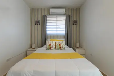 a bedroom with a large white bed with yellow sheets at EDMA APARTAHOTEL in Santa Bárbara de Samaná