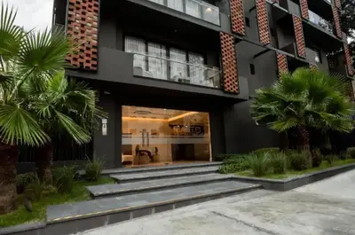 a building with palm trees in front of it at Torre Rialto in Santiago de los Caballeros