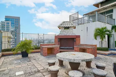 a patio with a table and a brick oven at Exquisite Oceanfront Suite in Santo Domingo