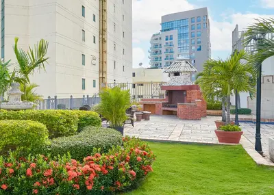 a courtyard with a garden with bushes and flowers at Exquisite Oceanfront Suite in Santo Domingo
