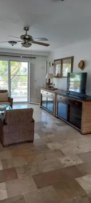 a living room with a couch and a ceiling fan at Room beach-front with private bathroom -Adults only in Punta Cana