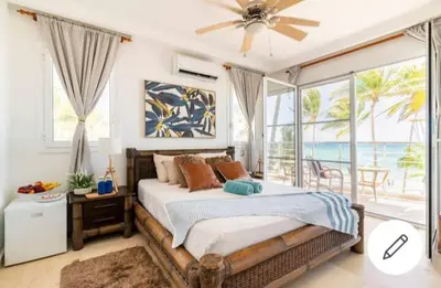 a bedroom with a bed with a view of the ocean at Room beach-front with private bathroom -Adults only in Punta Cana