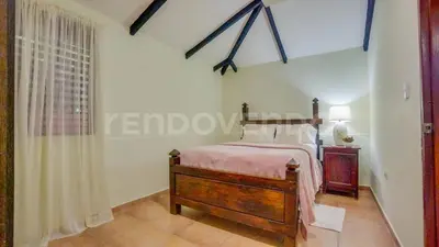 a bedroom with a bed in a room with a window at El Yaguacil villa in Jarabacoa
