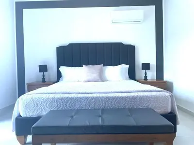 a bedroom with a large bed with a blue bench at Gaia Residence Deluxe in San Felipe de Puerto Plata