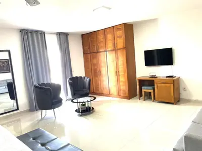 a living room with a tv and a desk and chairs at Gaia Residence Deluxe in San Felipe de Puerto Plata