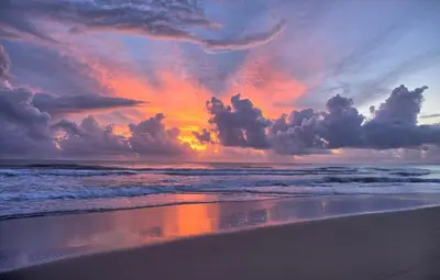 a sunset on a beach with the ocean at Amazing ocean view apartment with grand pool in Cabarete