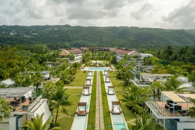 an aerial view of a resort with a pool and palm trees at Go away to this charming apt at Sublime w private jacuzzi included in Las Terrenas