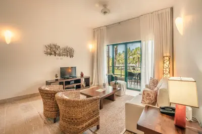 a living room with a couch and a table and chairs at Go away to this charming apt at Sublime w private jacuzzi included in Las Terrenas