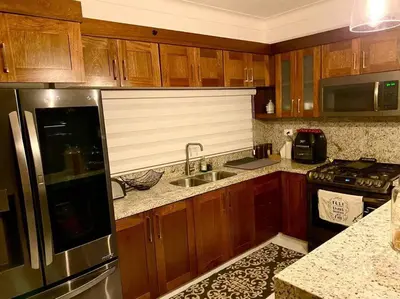 a kitchen with wooden cabinets and a stainless steel refrigerator at Spectacular PentHouse with private jacuzzi terrace in Santiago de los Caballeros