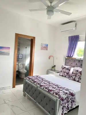 a bedroom with a large bed and a toilet at 5 Star Villa minutes from Airport and Beaches in Sosúa