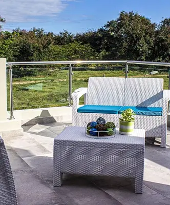 a patio with two chairs and a table with a bowl of fruit at 5 Star Villa minutes from Airport and Beaches in Sosúa