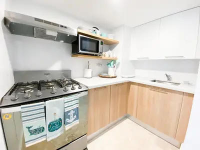 a kitchen with a stove and a microwave at Xeliter Green One Playa Dorada in San Felipe de Puerto Plata
