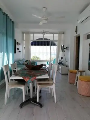 a dining table and chairs in a living room at Indy's Best Bay FrontView in Samana. in Santa Bárbara de Samaná