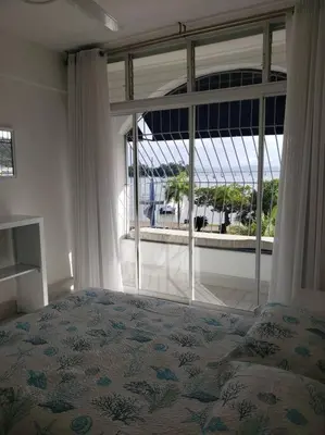 a bedroom with a bed and a large window at Indy's Best Bay FrontView in Samana. in Santa Bárbara de Samaná