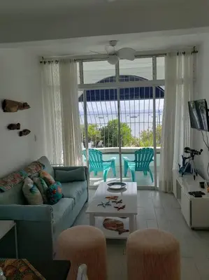 a living room with a blue couch and a table at Indy's Best Bay FrontView in Samana. in Santa Bárbara de Samaná