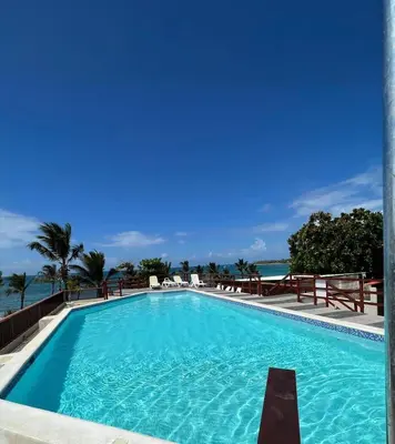a swimming pool with the ocean in the background at Lovely Beachfront 2 bedrooms condo with 2 pools in Las Terrenas