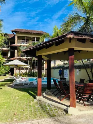 a house with a gazebo and chairs next to a pool at Lovely Beachfront 2 bedrooms condo with 2 pools in Las Terrenas