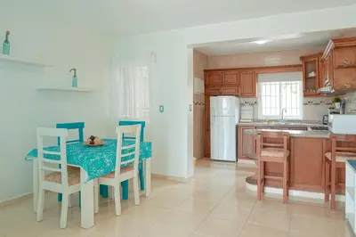 a kitchen with a table and chairs and a kitchen with a refrigerator at Ria Hotel in San Felipe de Puerto Plata