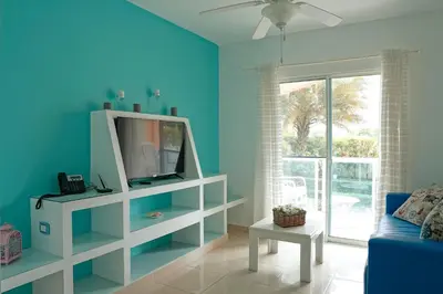 a living room with blue walls and a tv at Ria Hotel in San Felipe de Puerto Plata