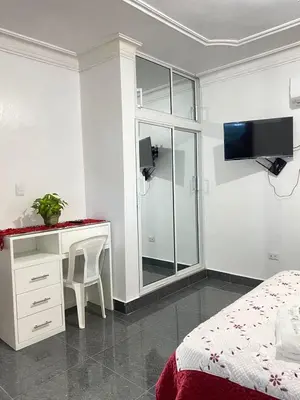 a bedroom with a bed and a desk and a tv at Complejo Ecoturistico Rancho Cielo in Licey al Medio