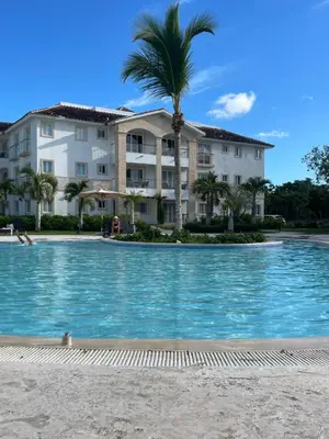 a hotel with a palm tree in front of a swimming pool at Hotel Palmera Bayahibe in Bayahibe