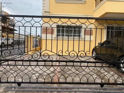 a black fence in front of a yellow building at Beautiful Penthouse in La Vega, RD in Concepción de La Vega
