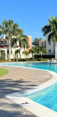 a swimming pool with palm trees in a resort at Sweet Home in Santiago de los Caballeros