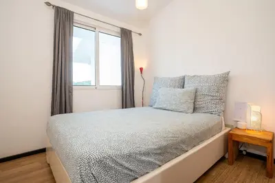 a white bedroom with a bed with a window at Piece of Paradise in Las Terrenas