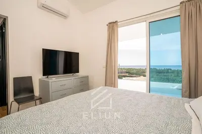 a bedroom with a bed and a television and a window at Piece of Paradise in Las Terrenas