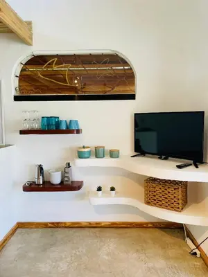 a living room with a tv on a white wall at Villa Tortuga, Guest house Private bungalow, private pool in Las Terrenas