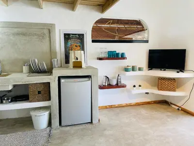 a kitchen with a small refrigerator in a room with a tv at Villa Tortuga, Guest house Private bungalow, private pool in Las Terrenas