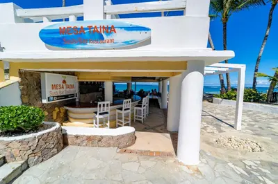 a restaurant with a surfboard on top of a building at Kite Beach Oceanfront 1st Row Two Bedrooms and patio in Cabarete