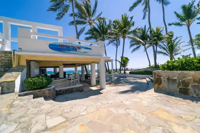 a building with a sign on the beach at Kite Beach Oceanfront 1st Row Two Bedrooms and patio in Cabarete