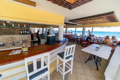 a bar at a restaurant with the ocean in the background at Studio Beachfront Kite Beach in Cabarete