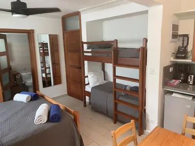 a room with two bunk beds and a bathroom at Studio Beachfront Kite Beach in Cabarete