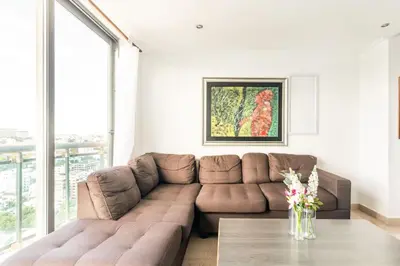 a living room with a brown couch and a table at Luxurious 2BDR condo located in Prestigious Tower. in Santo Domingo