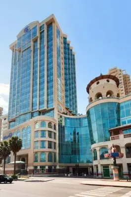 a large building with glass windows in a city at Luxurious 2BDR condo located in Prestigious Tower. in Santo Domingo