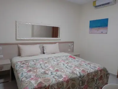 a bedroom with a bed with a floral comforter at CoralK Apartments Sosúa in Sosúa