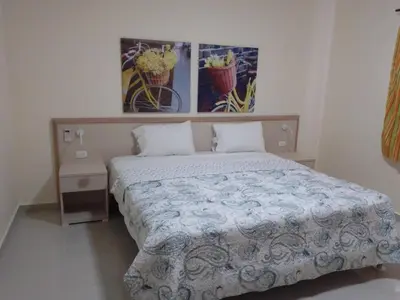 a bedroom with a bed and two pictures on the wall at CoralK Apartments Sosúa in Sosúa